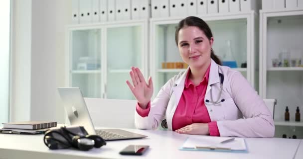 Jonge Vrouwelijke Arts Zwaaien Als Begroet Patiënt Online Videogesprek Telegeneeskunde — Stockvideo