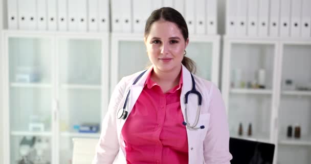 クリニックの白い医療コートで美しい笑顔の女性医師の肖像画 健康保険 サービスの概念 — ストック動画