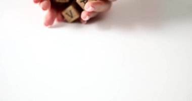 Female hands throw set of wooden dice with letters on palms closeup. Alphabetical learning and impaired reading and writing