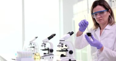 Scientist examines work in laboratory in test tube with crude oil. Analysis of oil and oil products
