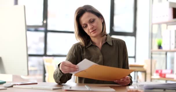 女人从黄色的信封里拿出信 仔细阅读 银行业务信函往来 — 图库视频影像