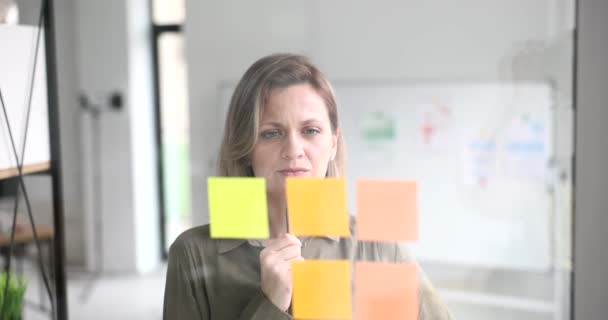 Tänksam Affärskvinna Ledare Moderna Universitetskansliet Tittar Klibbiga Anteckningar Projektstrategi Kreativa — Stockvideo