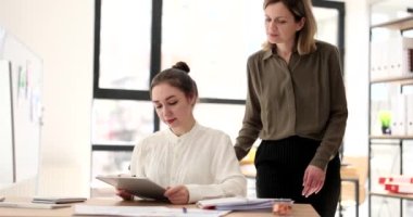 Seo leader helps student girl with report on work. Training and internship in company