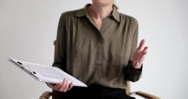 Silhouette of business woman holding documents gesturing with hands at conference. Communication with colleagues partner and speech at business meeting