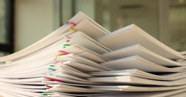 Stack of overloaded document paper with colorful paper clip on table. Bureaucratic business concept and business documentation processing