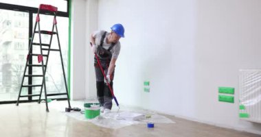 House painter paints wall of apartment with roller brush. Painting the walls and renovating house