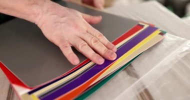 Male hand of designer or client looks at sheets of different colors. Choice of color and shade in interior