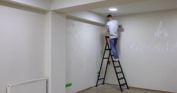 Male Builder Master Standing Ladder Painting Wall Interior Decoration Wall — Stockvideo