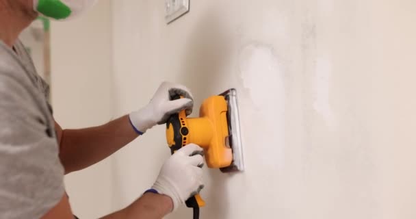 사람은 페인트칠을 손으로 표면을 닦는다 시멘트 연마기 — 비디오