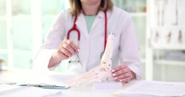 Doktor kemik modeline ayak basmayı açıklıyor. Bacak eklemlerinde ağrı