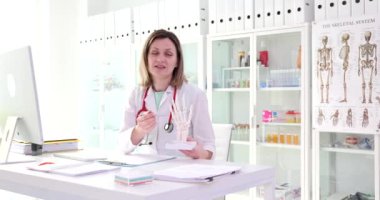 Doctor traumatologist showing anatomical model of human hand and explaining its structure in clinic 4k movie. Medical education traumatology and rheumatology concept