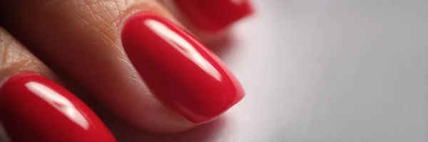 Beautiful red silk manicure on female nails. Classic bright red manicure
