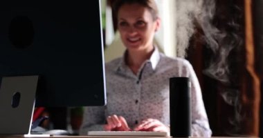Humidifier on desktop next to working woman. Desktop humidifier for office or home