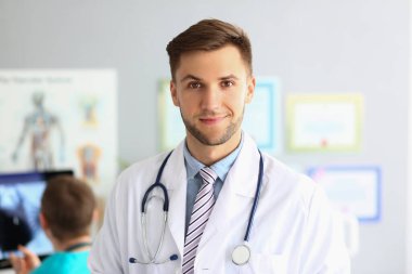 Friendly male general practitioner standing in office. Medical care and doctor appointment or insurance concept