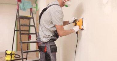 İnşaat teknisyenleri beton duvarı cilalamak için elle cilalama makinesi kullanıyorlar. Ev ve ofis için iç yenileme hizmetleri