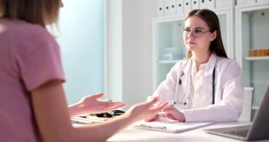 Kadın hasta hastanede konsültasyonda hemşire ya da pratisyen hekimle konuşuyor. Endişeli kadın klinikteki doktora danışıyor.