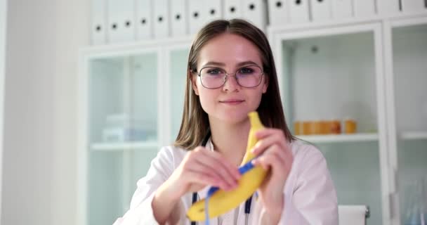 医師の女性泌尿器科医は バナナを保持し 手でテープを測定します 勃起不全と弱い勃起 — ストック動画