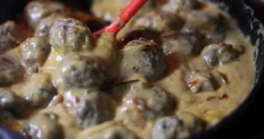 Ekşi krema soslu tavada ev yapımı köfte pişirmek. Ev yapımı et yemekleri.