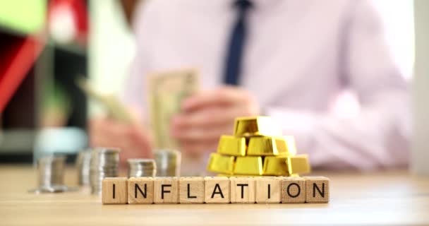 木制立方体上的通货膨胀与金条和成堆的硬币放在桌上 成本上升和通货膨胀 — 图库视频影像