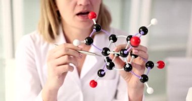 Kadın bilim adamı laboratuarda moleküler yapının modelini gösteriyor. Araştırma ve bilim konsepti