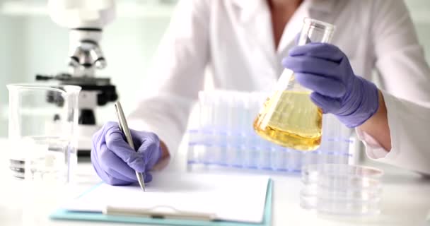 과학자들은 플라스크에서 노란색 액체의 실험실 실험을 의화학 — 비디오