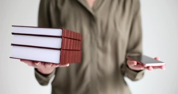 Kvinna Hålla Böcker Och Mobiltelefon Händerna Och Jämföra Betydelse Närbild — Stockvideo
