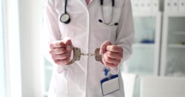Doktor, tıbbi personelin tutuklanması ve yolsuzluğun kelepçelenmesi için ellerini uzattı. Sağlık hizmetleri kavramında tutuklamalar
