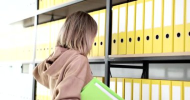 Belgelerle çalışan üzgün, yorgun bir kadın. Örgütün arşivi ve şirkette staj