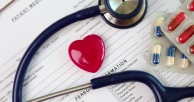 Kırmızı kalpli, steteskoplu ve haplı hasta geçmişi formu. Kardiyoloji ve sağlık ve sağlık sigortası