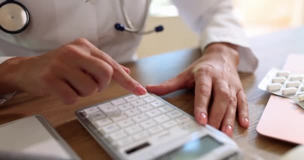 Doktor Używa Kalkulatora Sumowania Wszystkich Wydatków Koszt Ubezpieczenia Zdrowotnego — Wideo stockowe