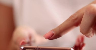 Kadın sergilenen parmağıyla cep telefonuna bakıyor. Mobil uygulamaların kullanımı