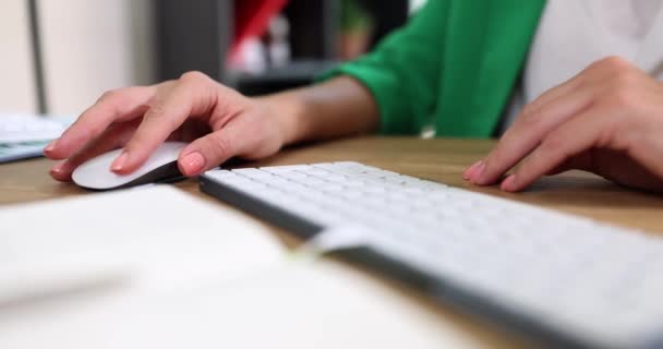 ワイヤレスコンピュータのマウスとコンピュータのキーボード上の女性の手 リモートワークトレーニングとインターネット上の情報の検索 — ストック動画