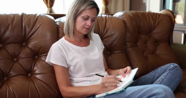 Schöne Junge Frau Schreibt Notizbuch Auf Sofa Schreiben Sie Gedanken — Stockvideo