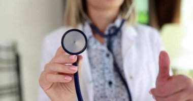 Doktor kardiyolog stetoskop tutuyor ve onaylıyor. Tıbbi muayene önerilir.