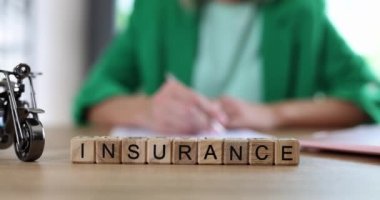 Araç ve motosiklet sigortası sözleşmesi. Motosiklet modeli ve sigorta kelimeleri masadaki tahtadan yapılmış.