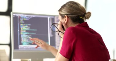 Elinde gözlük olan kadın programcı bilgisayar ekranı 4k filminde ağır çekimde bilgi çalışıyor. Bilgisayar programları kavramının gelişimi