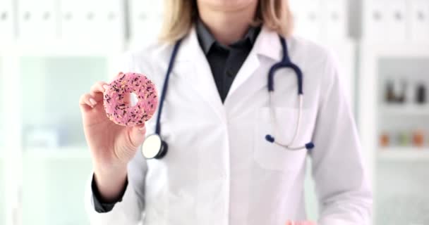 甘いピンクのドーナツを示す医師栄養士は K映画スローモーションを閉じます 栄養の概念でジャンクフード余分な炭水化物 — ストック動画