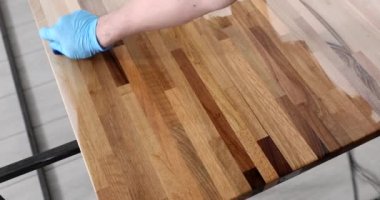 Mobilyacı ahşap tahtayı yağ ile işliyor ve 4K 'lık filmi yavaş çekimde cilalıyor. Mobilya üretim konsepti