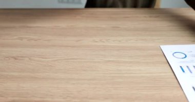 Sekreter ofisteki 4K filminde üzerinde grafikler olan belgeler hazırlıyor. Seminerler ve iş toplantıları konsepti düzenlemek