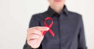 HIV 'e karşı mücadelenin kırmızı kurdele sembolü olan 4K' lık filmi ağır çekimde tutan kadın. HIV önleme ve yardımcı kavramı