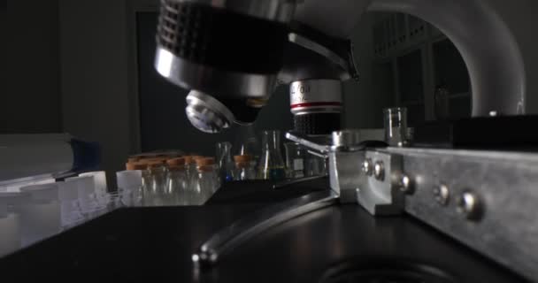 化学実験室のテーブルの上の顕微鏡や試験管の多くは 4Kの映画のスローモーションを閉じます 製薬業界のコンセプト — ストック動画