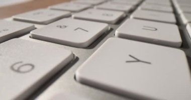 Beyaz bilgisayar klavyesindeki düğmeler 4K 'lık filmi yavaş çekimde kapatır. Konseptte programlama ve çalışma