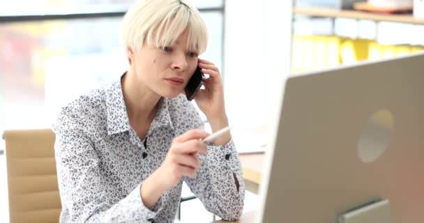 Kadını Ofis Filminde Cep Telefonuyla Bilgisayarın Önünde Ağır Çekimde Konuşuyor — Stok video