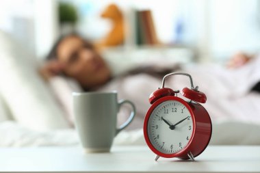Saat 10 'da kırmızı alarm ve uyuyan kadın. Huzurlu uyku ve geç uyanma konsepti