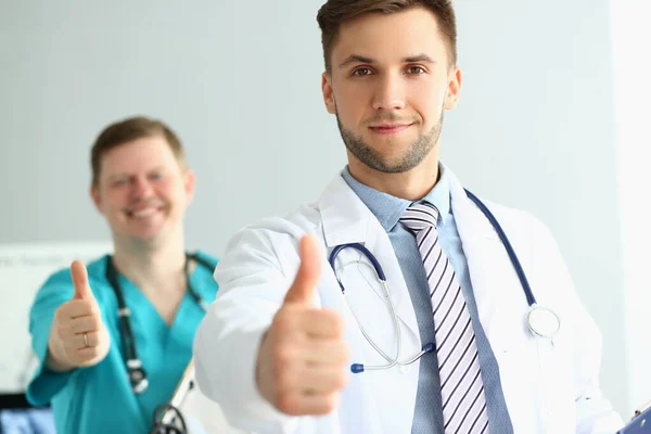 Dwóch Lekarzy Podnosi Kciuki Klinice Zalecając Opiekę Medyczną Koncepcja Ubezpieczenia — Zdjęcie stockowe