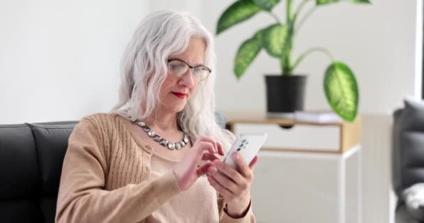 老太婆灰白的头发在家里用手机打4K电影慢动作 与年龄亲属的远程通信概念 — 图库视频影像