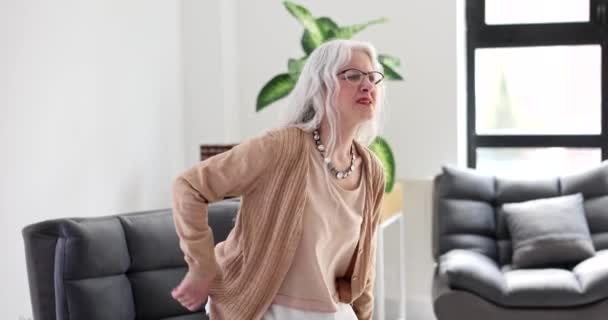 Wanita Tua Bangun Dari Sofa Dan Menahan Sakit Kembali Rumah — Stok Video