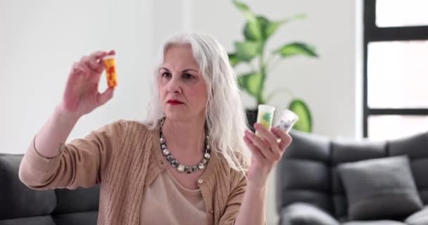 Mujer Mayor Mirando Frascos Medicina Casa Película Cámara Lenta Tratamiento — Vídeo de stock