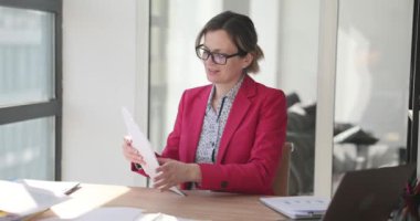 Kadın yönetici ofiste belgelerle çalışıyor. Belgelendirme ve mali raporlama ile çalış