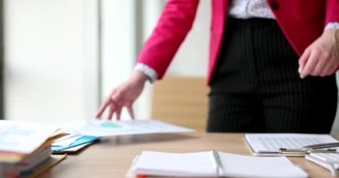 Hoşnutsuz CEO sözleşmeyi okur ve öfkeyle masaya yaslanır. Pazarlamacı analisti rapordaki hatadan memnun değil